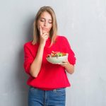 Woman wondering if her meal is going to make her unwell or not.