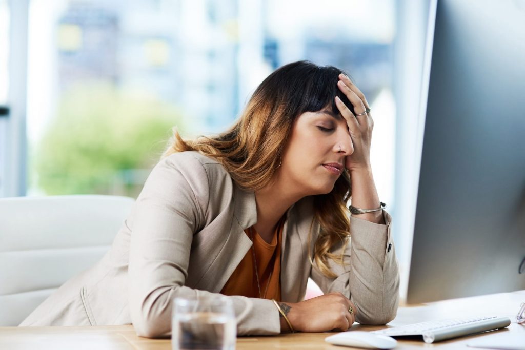 Woman feeling fatigue at work with digestive system problems