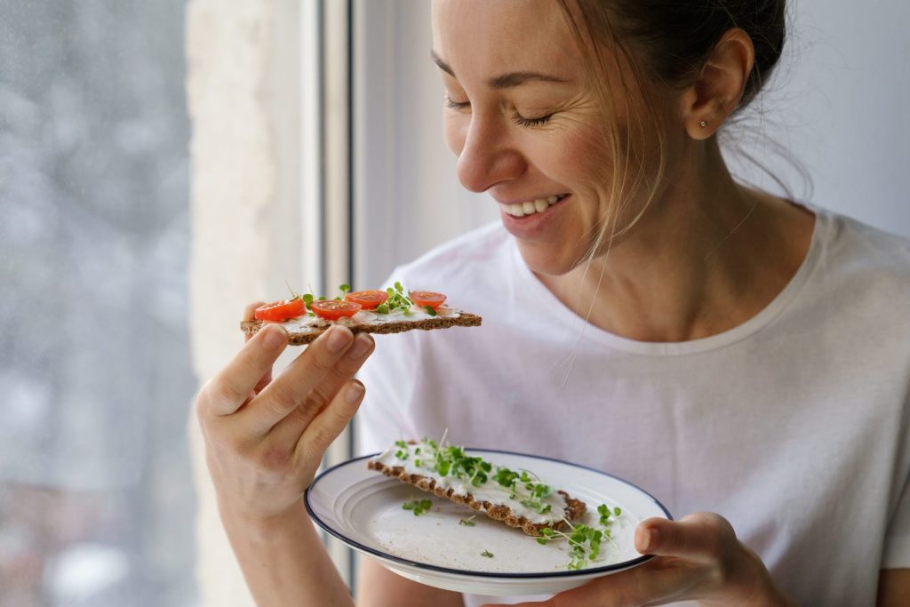 Woman happily eating gluten-free crsipbread