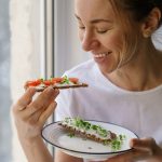 Woman happily eating gluten-free crsipbread