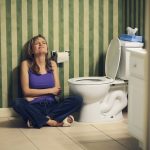 Woman suffering from constipation at the toilet